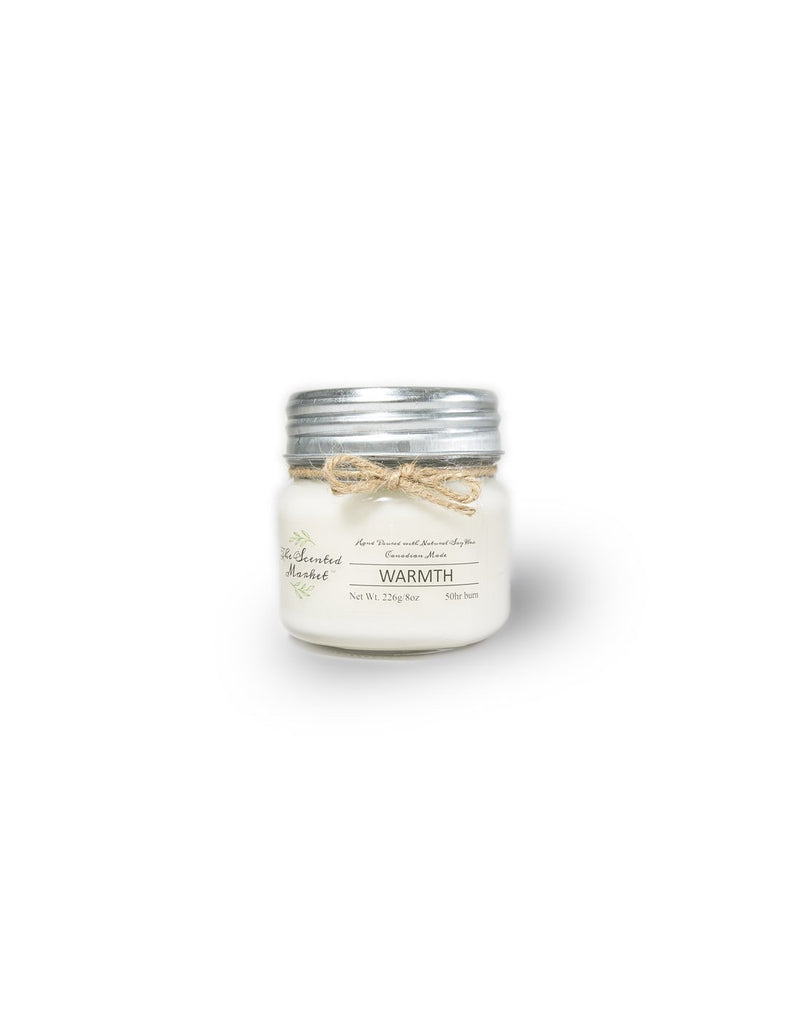 The Scented Market Warmth 8oz Soy Wax Candle front view in a glass jar with metal lid and tied with a twine bow